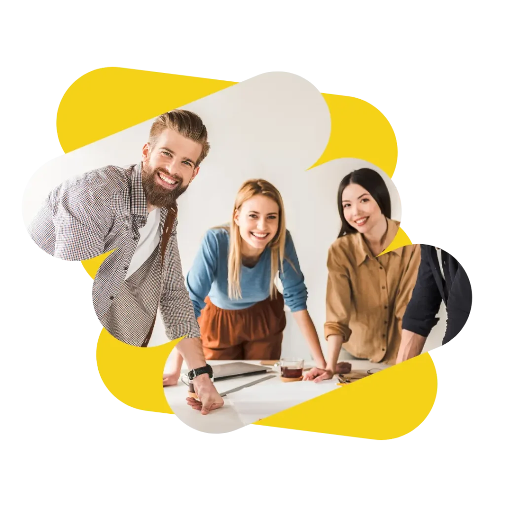 Équipe de travail souriante debout, appuyés sur une table de réunion.